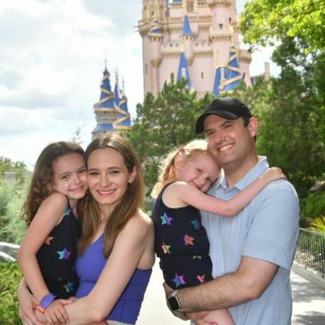 uma família sorrindo em frente ao castelo da cinderela no Magic Kingdom Park