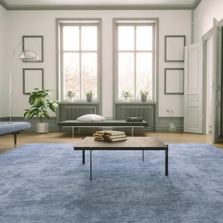um tapete de área azul adiciona cor e suavidade a uma sala de estar